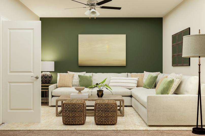 Rendering of loft space showing white
  couch and coffee table along a green accent wall and ceiling fan above with
  beige capret flooring throughout.