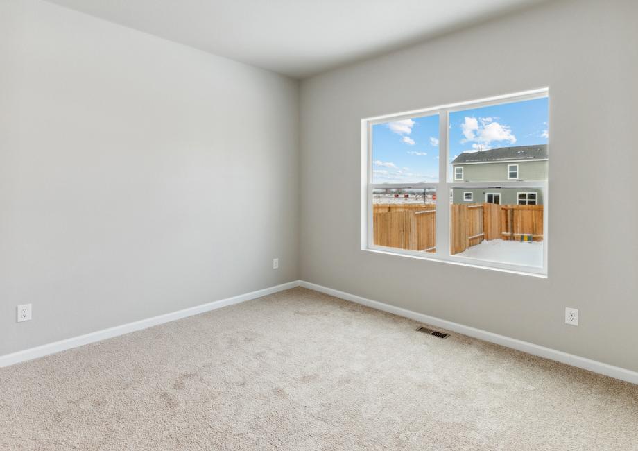 Master bedroom with large windows, creating a bright space.