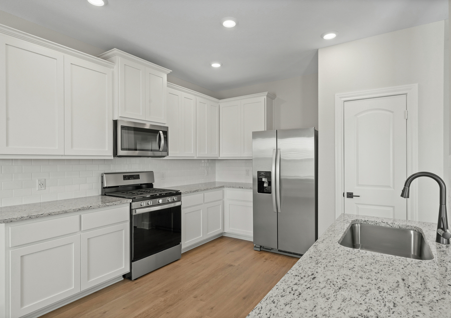 The upgraded kitchen has beautiful white wood cabinetry.