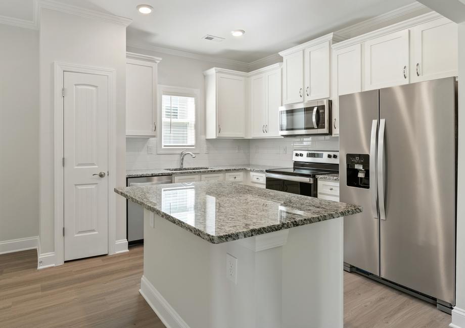 Kitchen with a granite island and white cabinets.