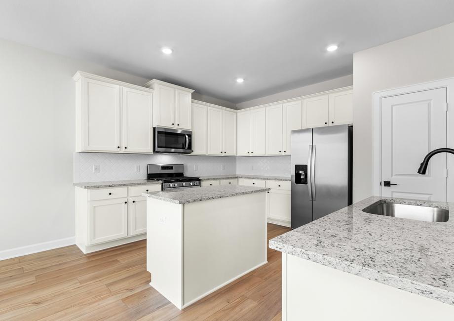 Kitchen with white cabinetry, tile backsplash and granite counters.
