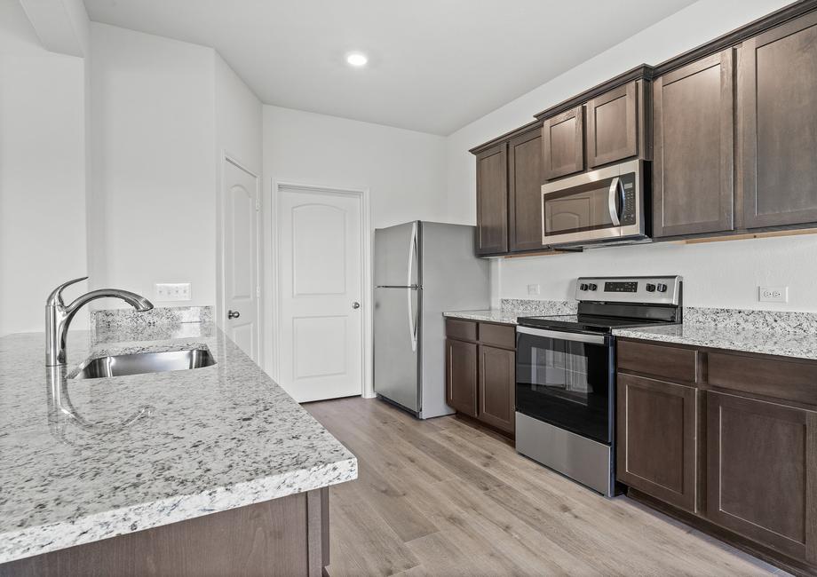 The kitchen of the Cypress has beautiful wood cabinetry.