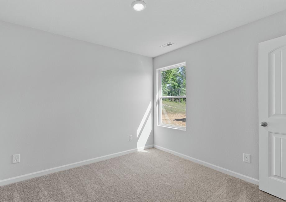 Secondary bedroom with carpet and a single window.