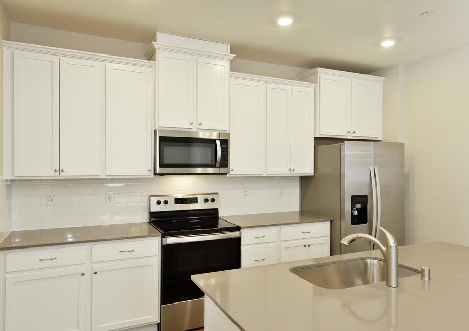 The kitchen has stainless steel appliances and plank flooring.