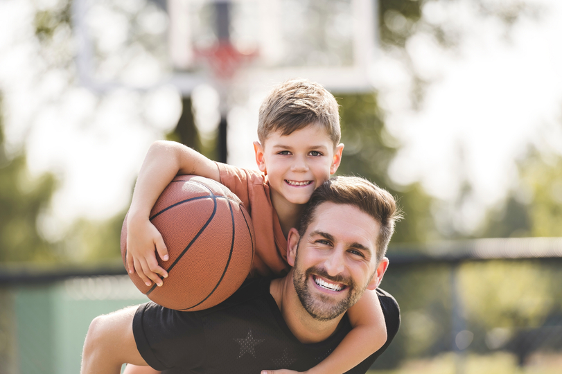 Father and son playing basket ball.