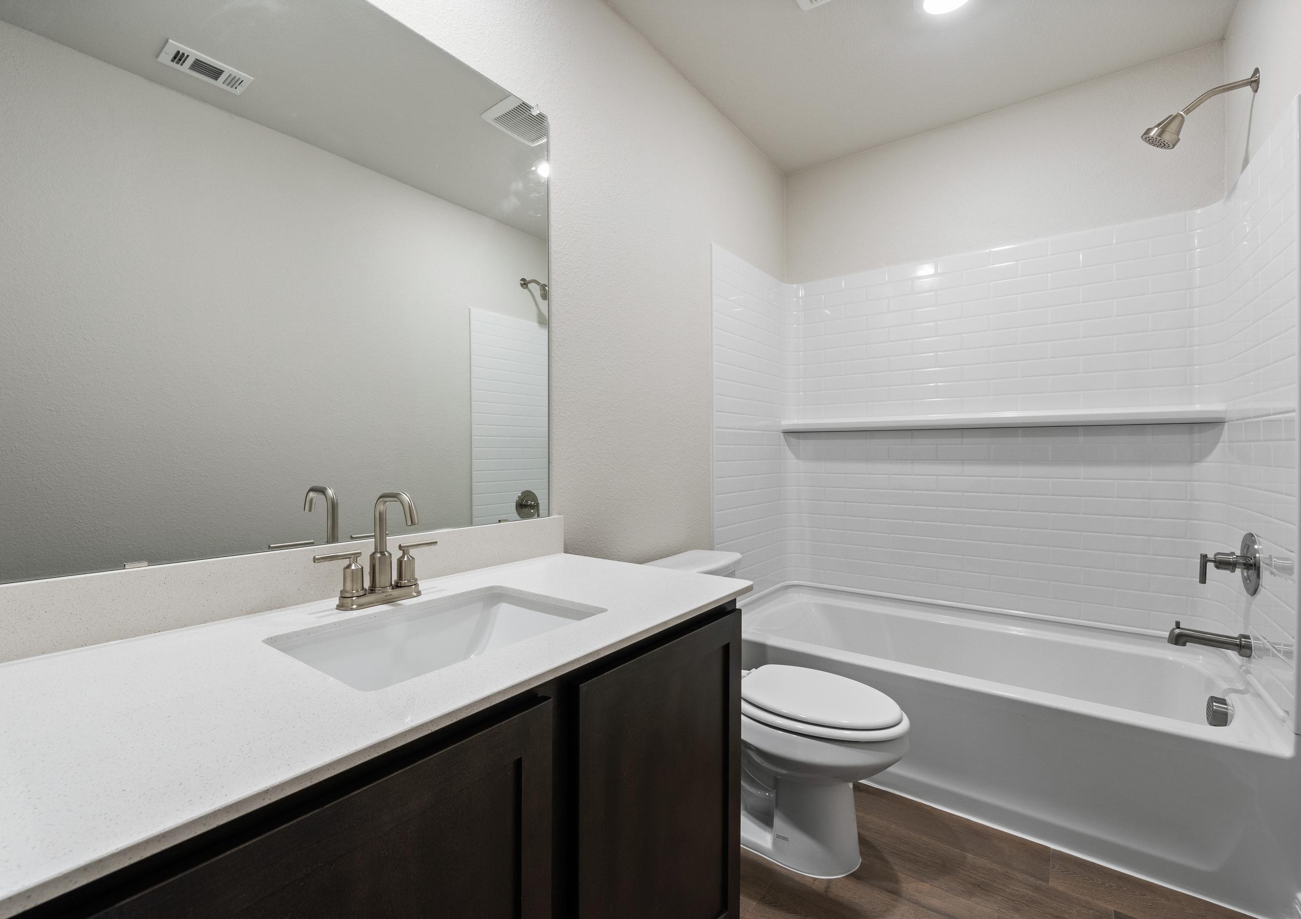 The secondary bathroom of the Rayburn has a large vanity space and a shower-tub combo.