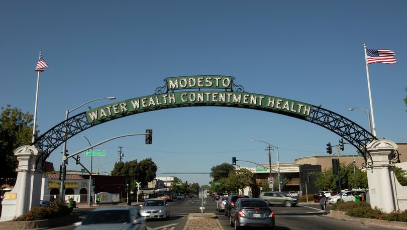 Daytime view of the historic 1912 Modesto Arch as it spans over I Street through downtown Modesto.