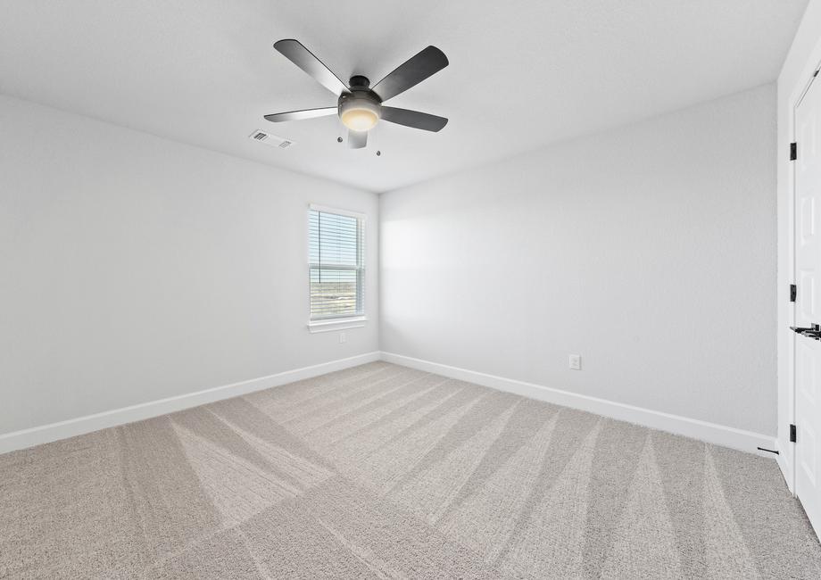 Take a look at the first secondary bedroom featuring plush carpets, a large window, and double doors to the closet.