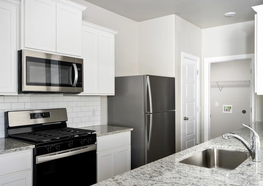 The kitchen of the Coastal has beautiful white cabinets.