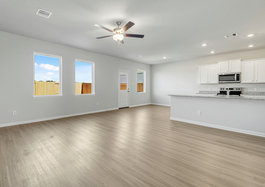 A family room with an adjoining kitchen and dining room