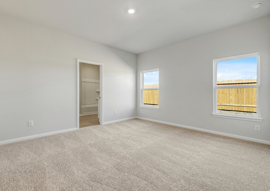 Master bedroom with two large windows overlooking the backyard