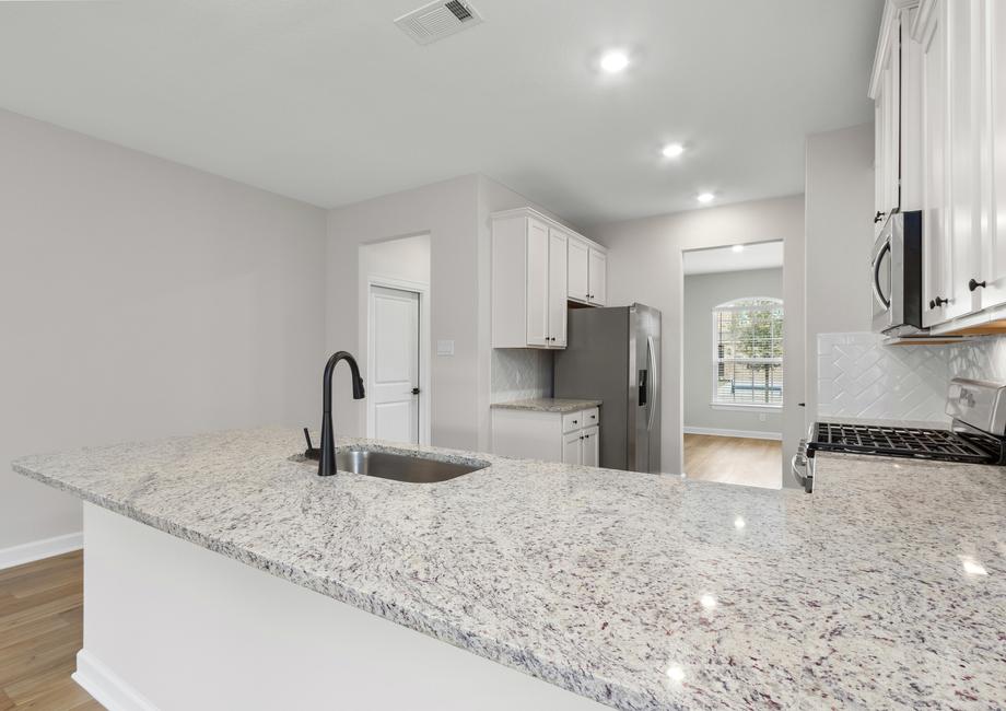 The kitchen features stunning countertops and ample storage space.