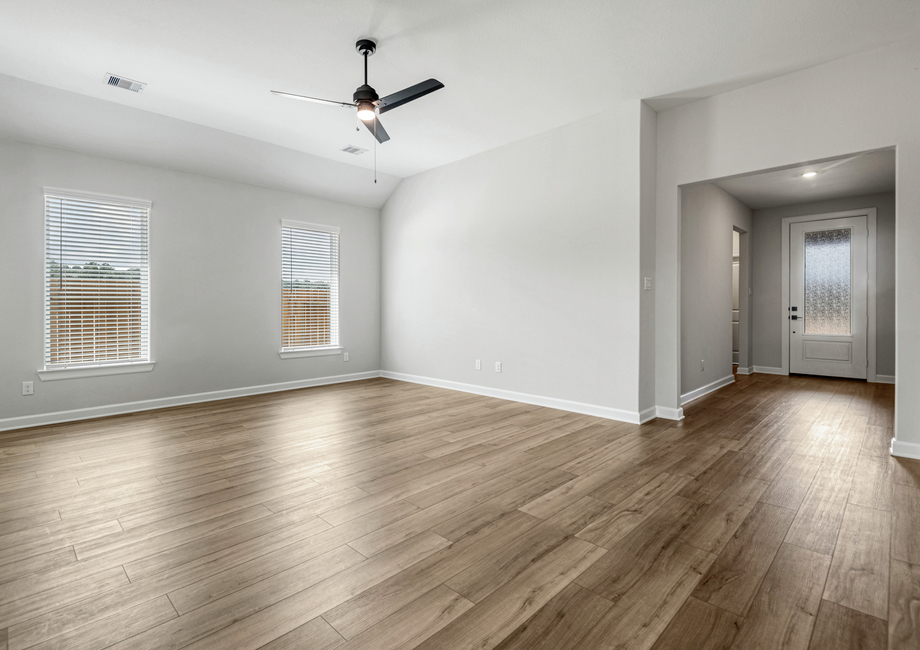 A foyer leads to a large family room with two windows