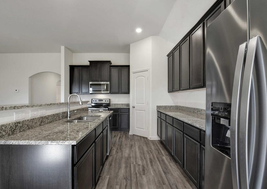 Kendall kitchen finished with hardwood floors, stainless steel appliances, and gray granite countertops