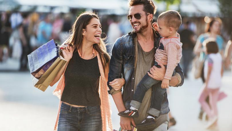 Young happy parents having fun while shopping with their son. 