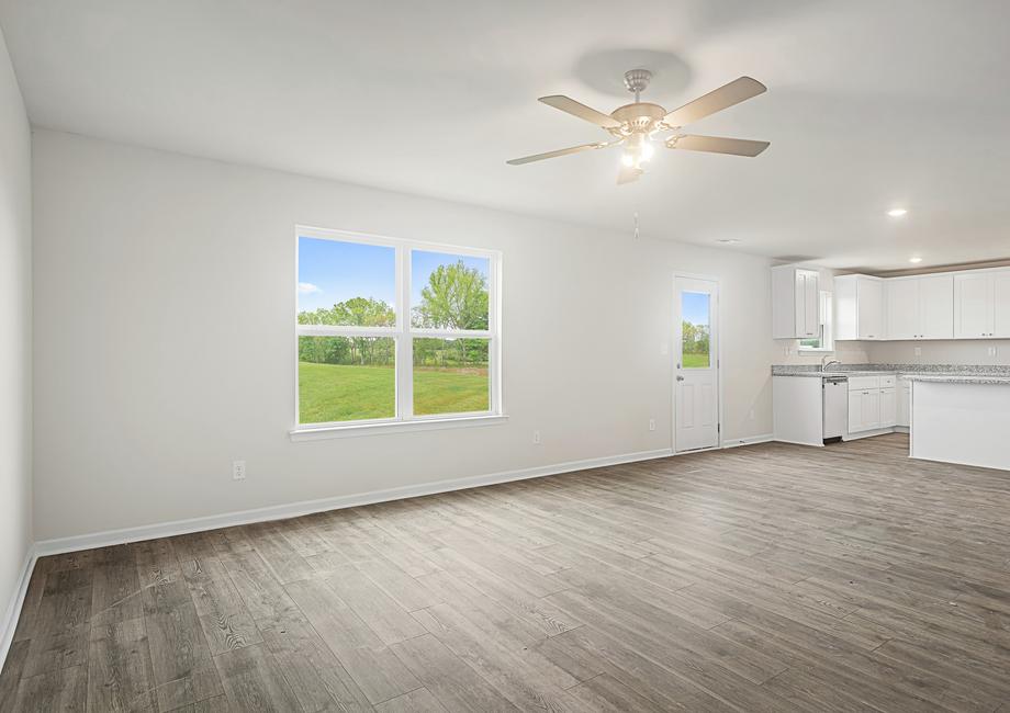 The spacious family room has a ceiling fan and plank flooring.