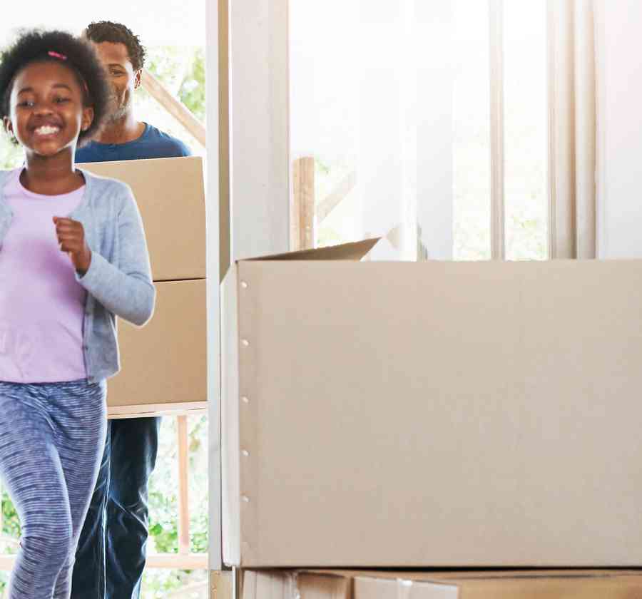 Family carrying boxes into their new home.