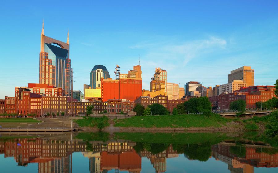 Nashville, Tennessee city buildings showing the still Cumberland River, industrial buildings, and tall skyscrapers