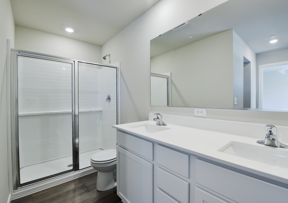 The master bathroom has a step in shower and a dual sink vanity.