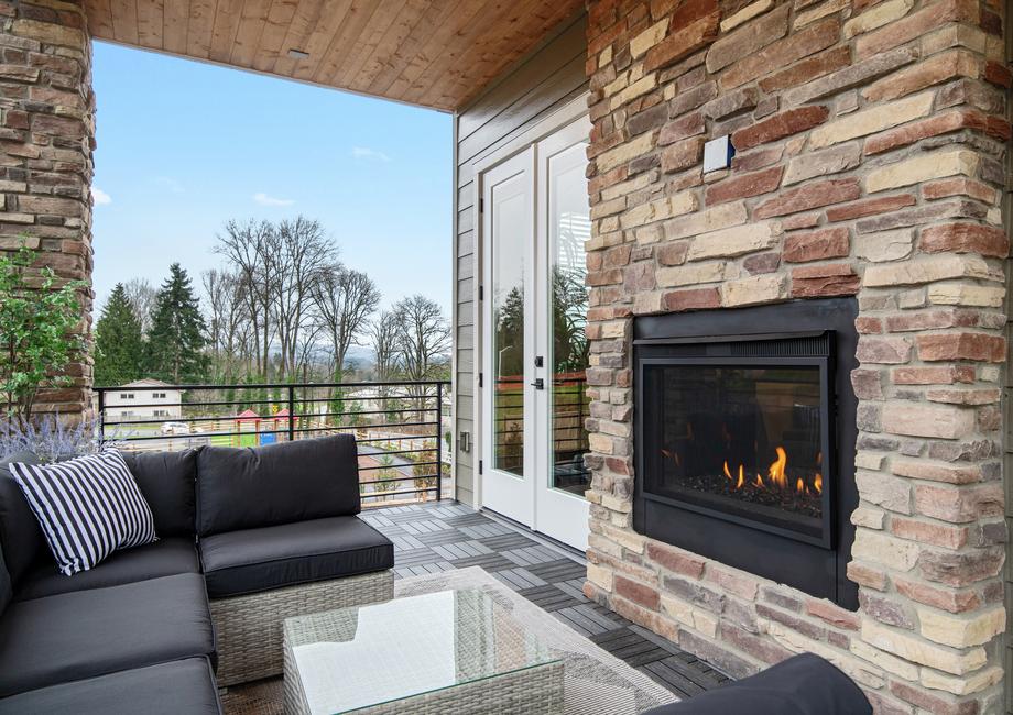 Outdoor living area includes a fireplace.