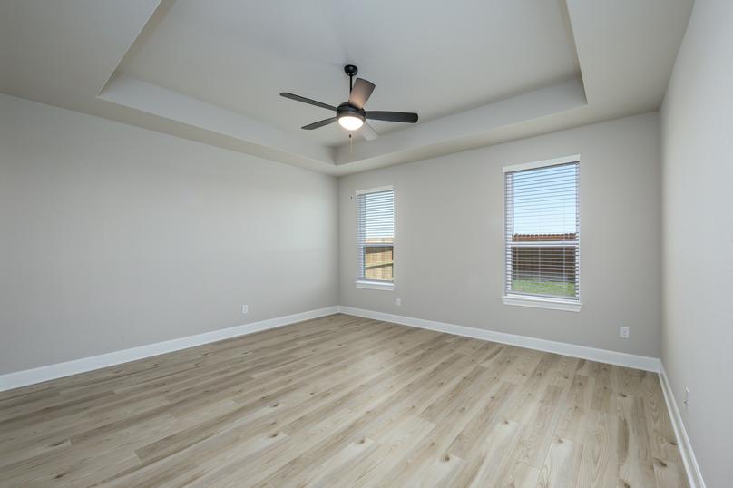 The master bedroom has a ceiling fan and luxury vinyl plank flooring.