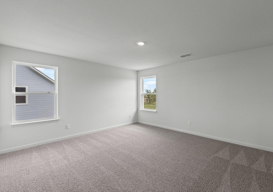 The spacious master bedroom has two windows that lets in natural light and backyard views.