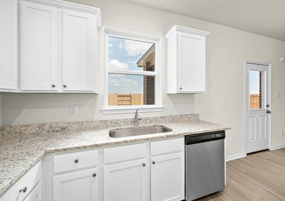 The kitchen has beautiful white cabinets and granite countertops