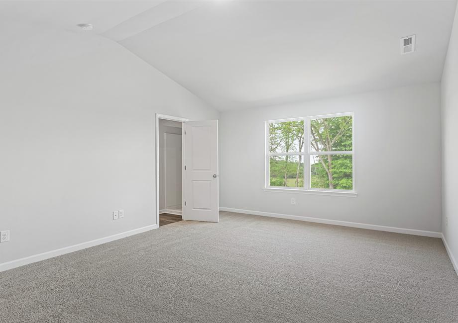 The master bedroom is so spacious and has an amazing large window.