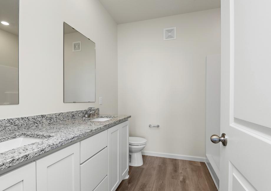 The master bathroom has a dual vanity and step in shower. 
