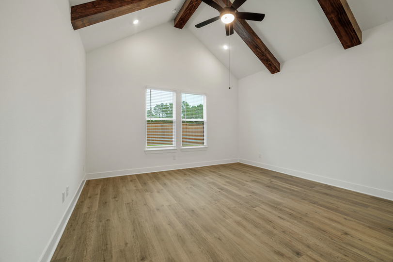 The primary bedroom includes beam accents.
