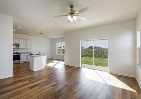 Large family room with luxury vinyl plan flooring and windows letting in natural sunlight