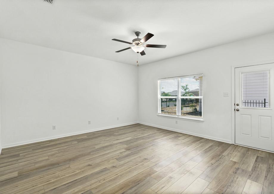 Spacious family room with a ceiling fan and large windows.