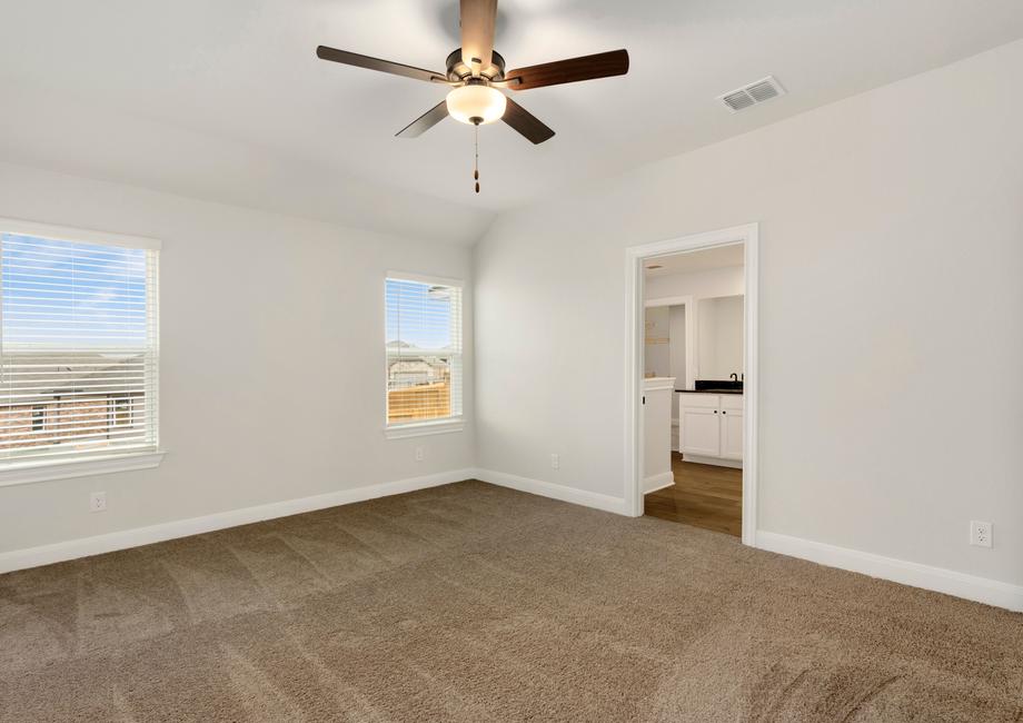 Master bedroom with two large windows and an attached bathroom.