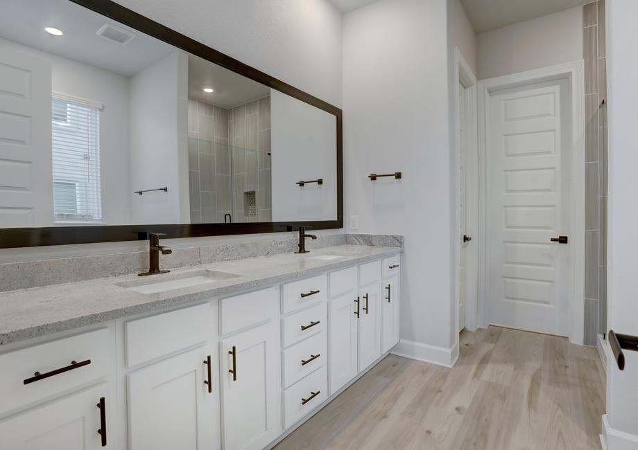 Master bathroom with two sinks and abundant storage space.