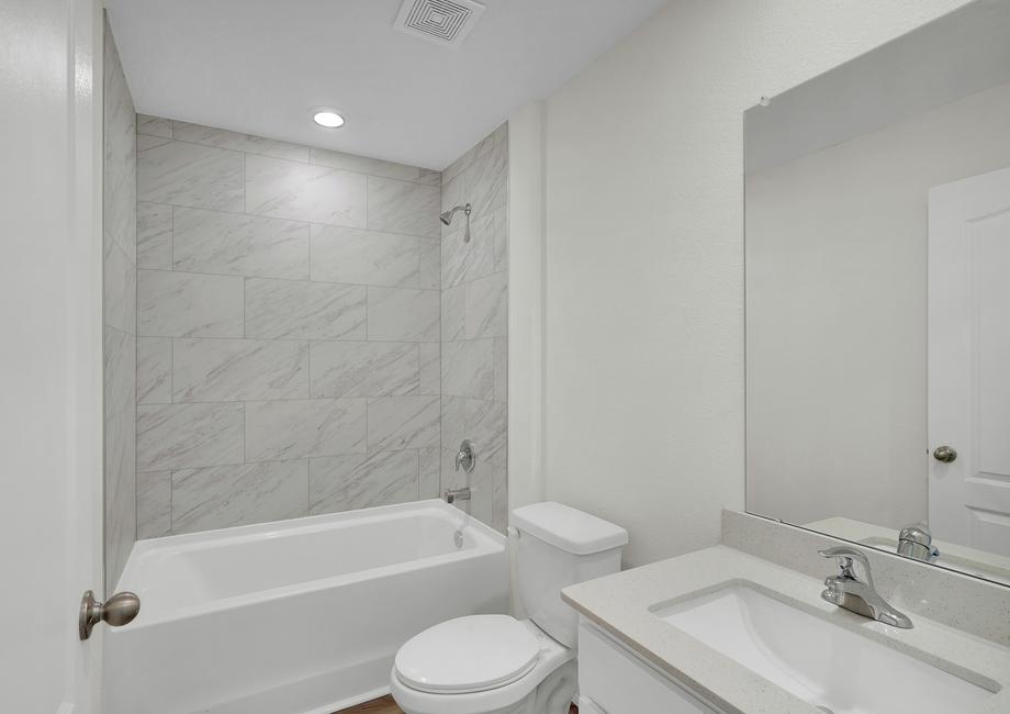 The secondary bathroom has a stunning vanity with a large soaker tub.