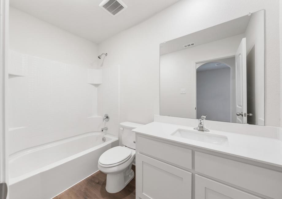 The secondary bathroom has a large vanity space and a shower-tub combo.