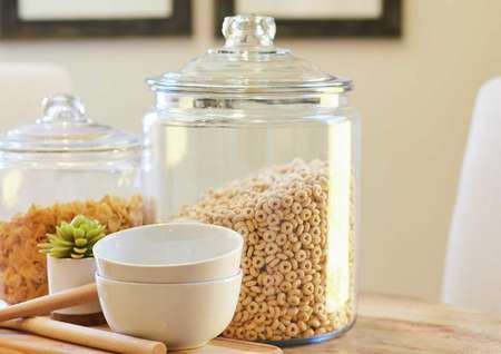 This kitchen is decorated with jars containing cereal, noodles, and white bowls.