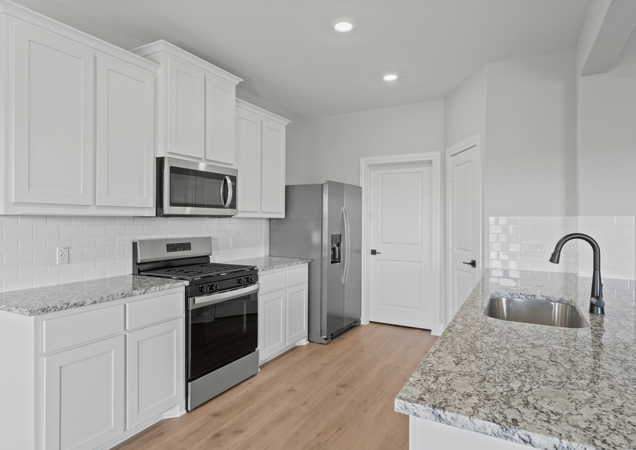 The kitchen has beautiful white wood cabinetry.