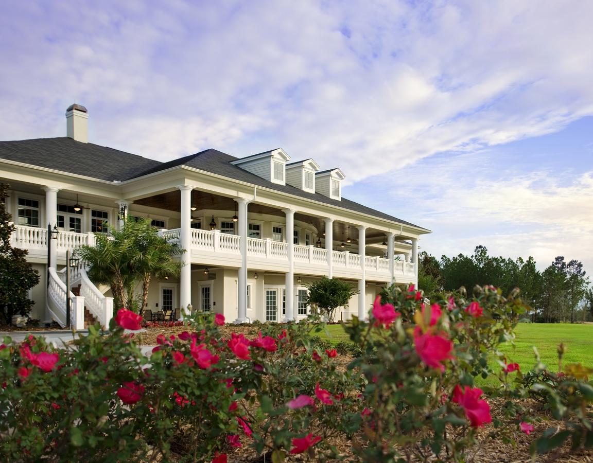 The Southern Hills Clubhouse with flowers and a blue sky.