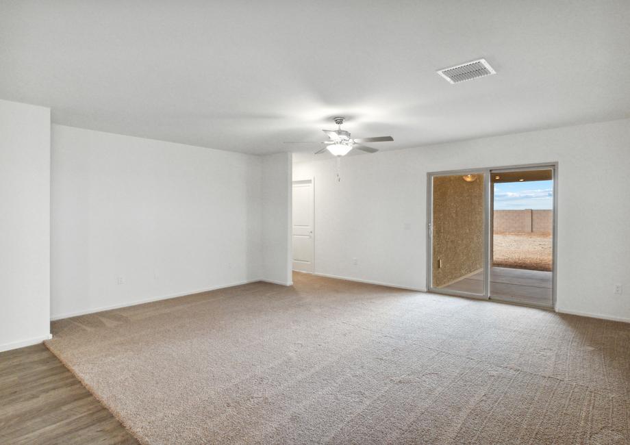 Expansive living room with a ceiling fan and overlooking the back porch.