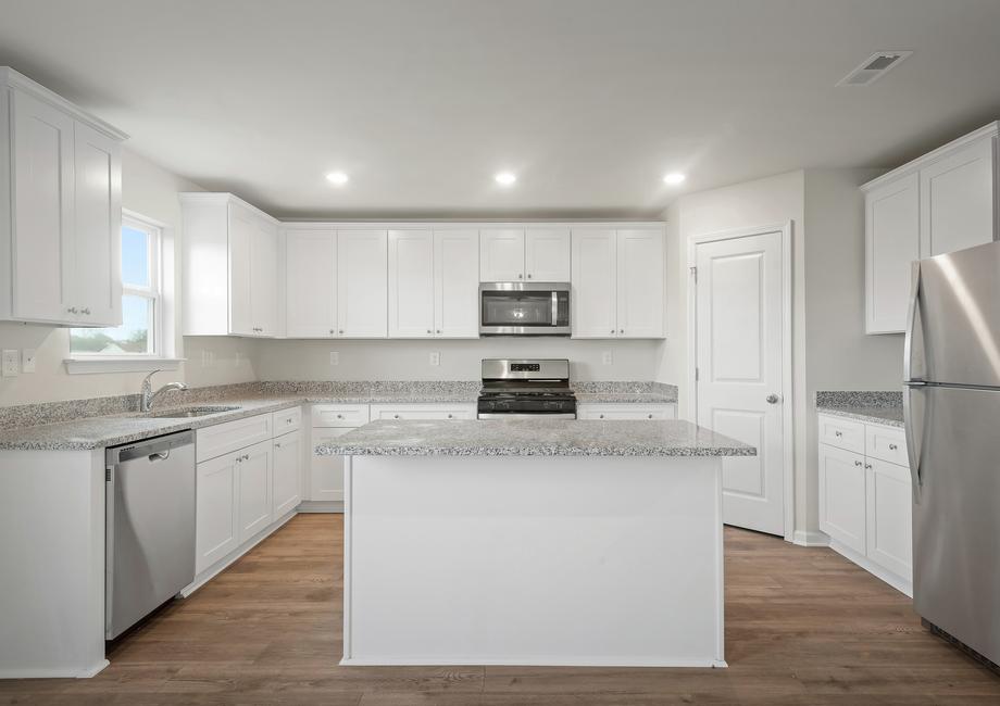 The kitchen has white cabinets and stainless steel appliances.