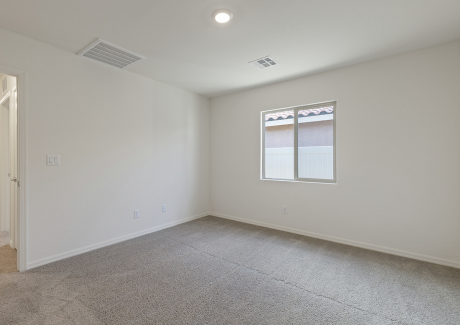 The master bedroom of the Aspen is spacious and has a large window.