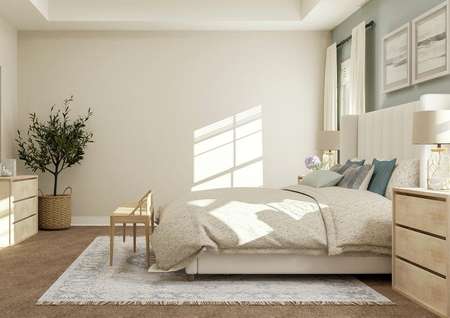 Rendering of spacious master bedroom
  showing beige dresser with décor on left and a large white bed with
  nightstand along a green accent wall on right with tan carpet flooring
  throughout.
