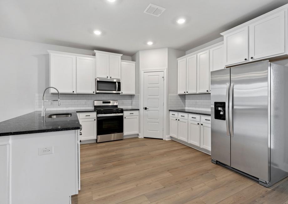 Chef-ready kitchen with designer finishes, like black countertops and white cabinets.