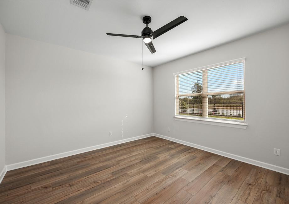 The master bedroom have luxury vinyl plank flooring and a ceiling fan.