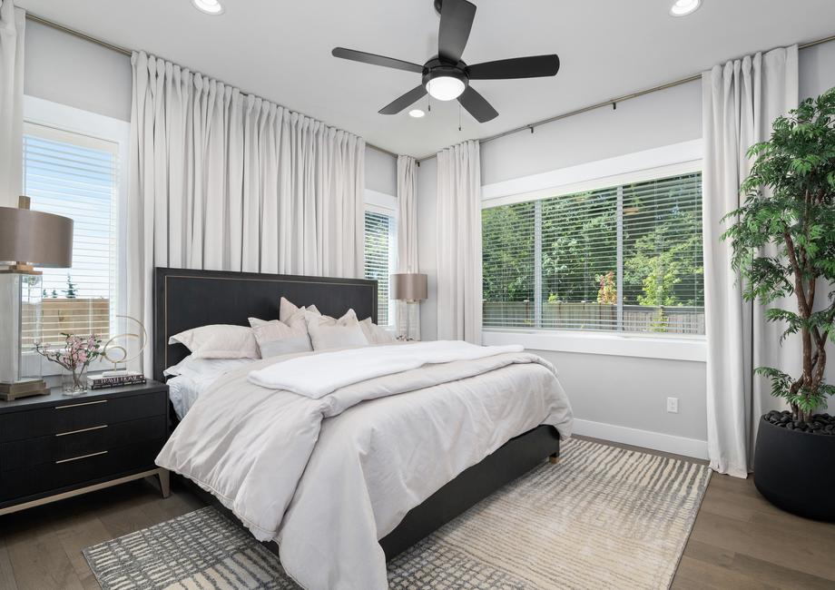 The master bedroom has lots of windows that flood the room with natural light.