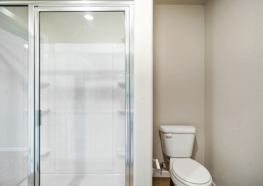 The master bathroom features a glass-enclosed shower.