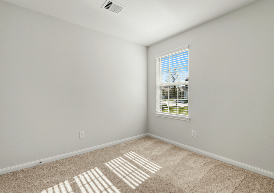 Secondary bedroom with lush carpet a window overlooking the front yard