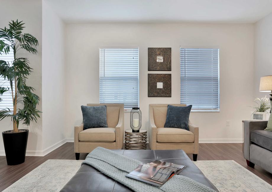 Pine model home staged with full furnishings including an indoor plant, beige colored sofa, and dark wooden coffee table