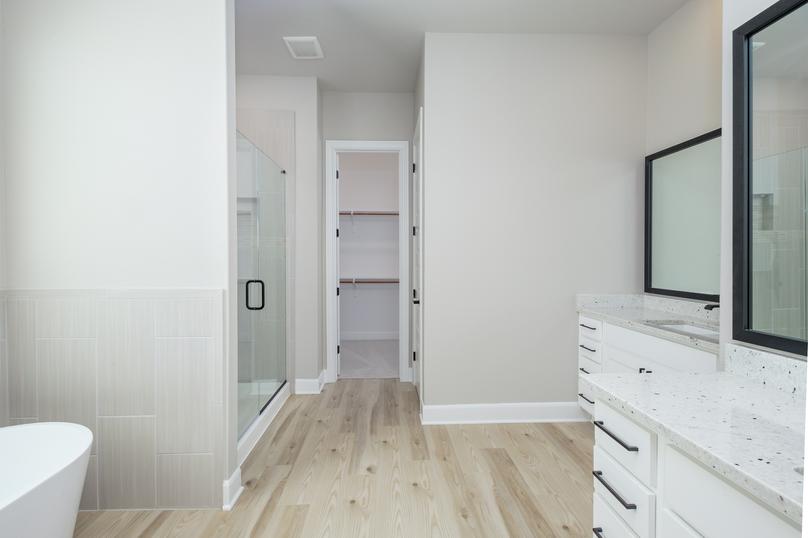 Two large vanities and a standalone tub are showcased in the master bath.